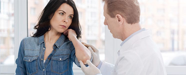 woman with a skin infection getting her skin checked by a dermatologist
