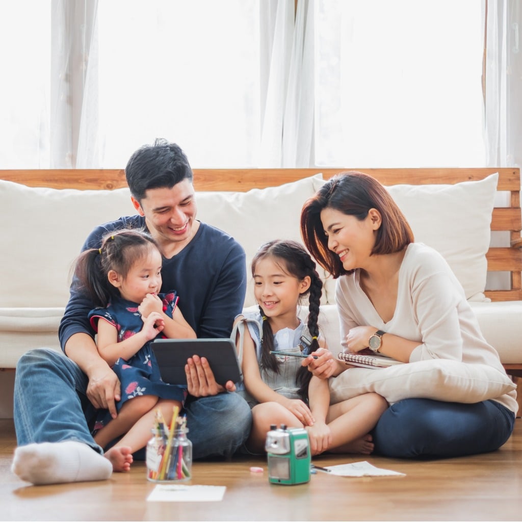 Happy family gathered around a laptop