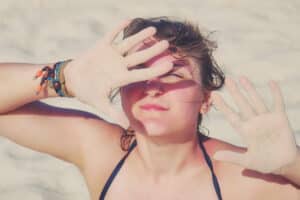A woman blocking the sun with her hands