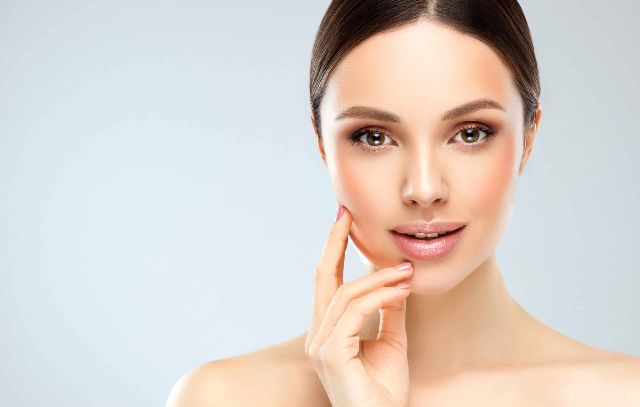 A woman touching her cheek after getting JUVÉDERM® for Smile Lines