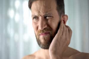 A man with a skin infection scratching his neck